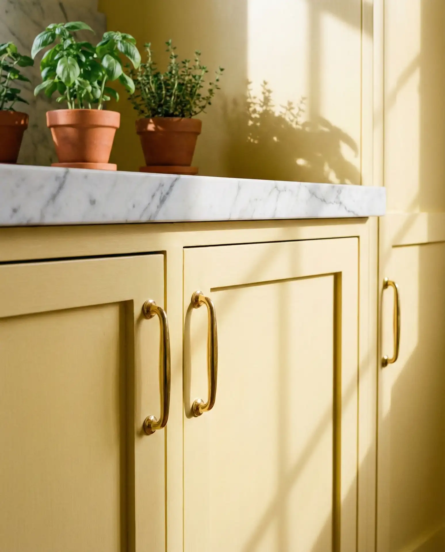Butter Yellow Cabinets with Marble Countertops 1
