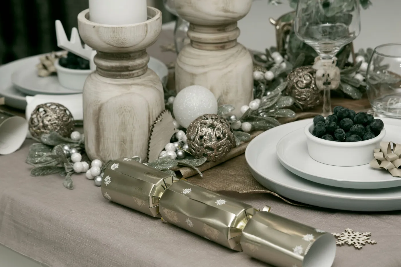 A beautifully decorated Christmas table with candles, ornaments, and festive tableware.