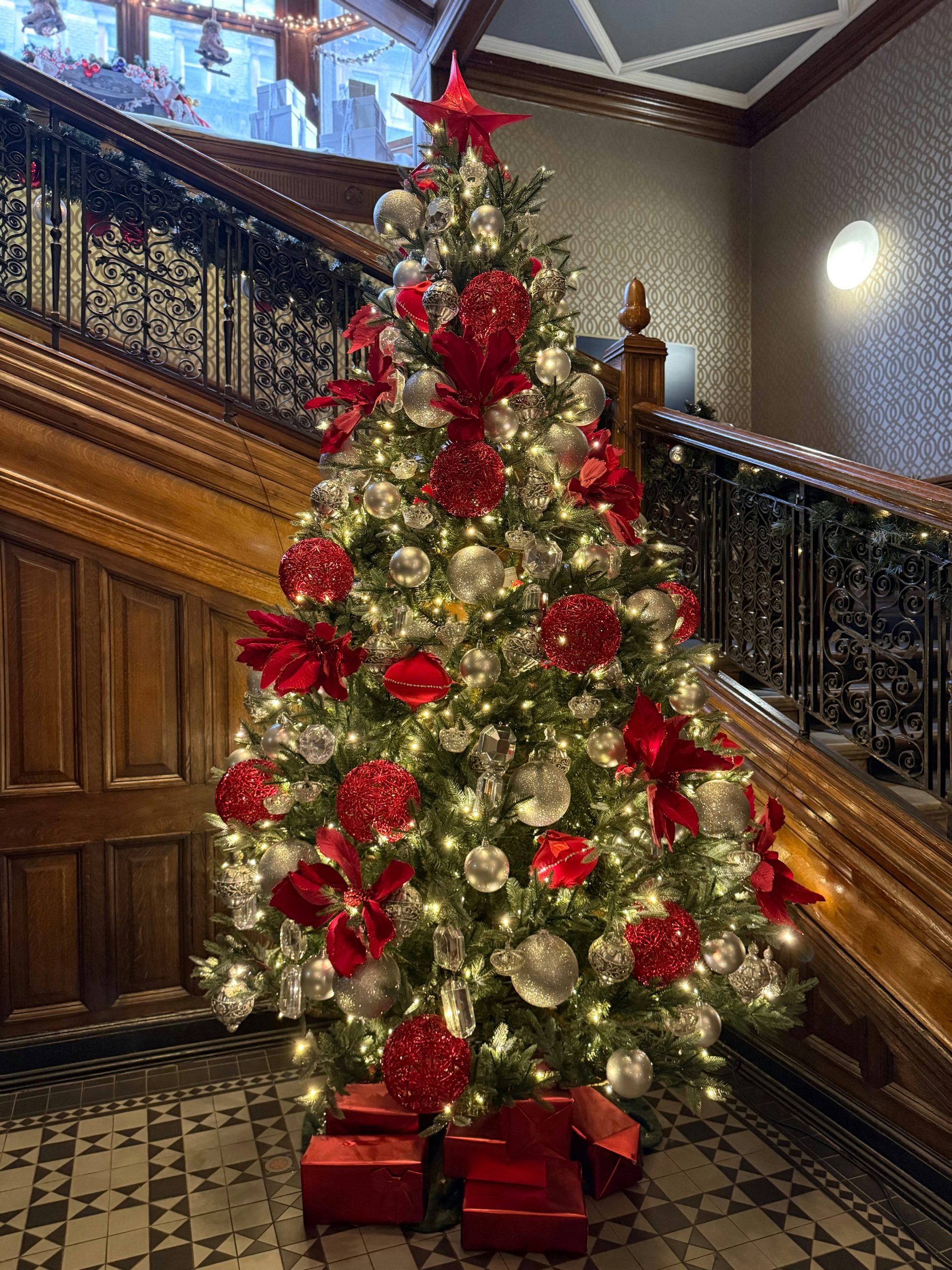 A beautifully decorated christmas tree with red and silver ornaments