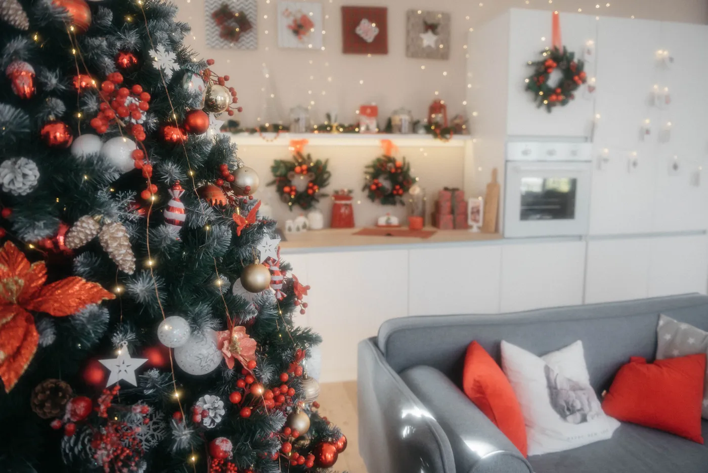 A beautifully decorated living room with a Christmas tree and festive lights, creating a cozy holiday atmosphere.