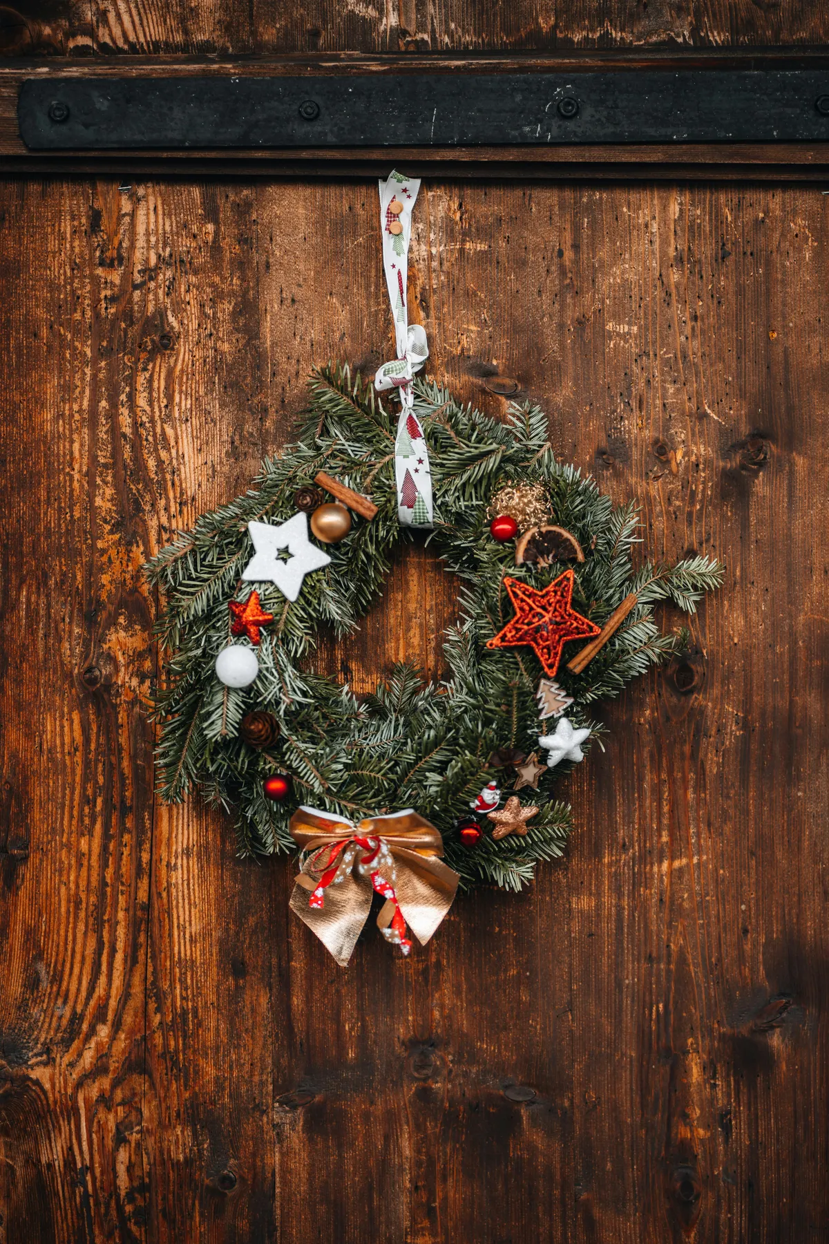 a christmas wreath hanging on a wooden door