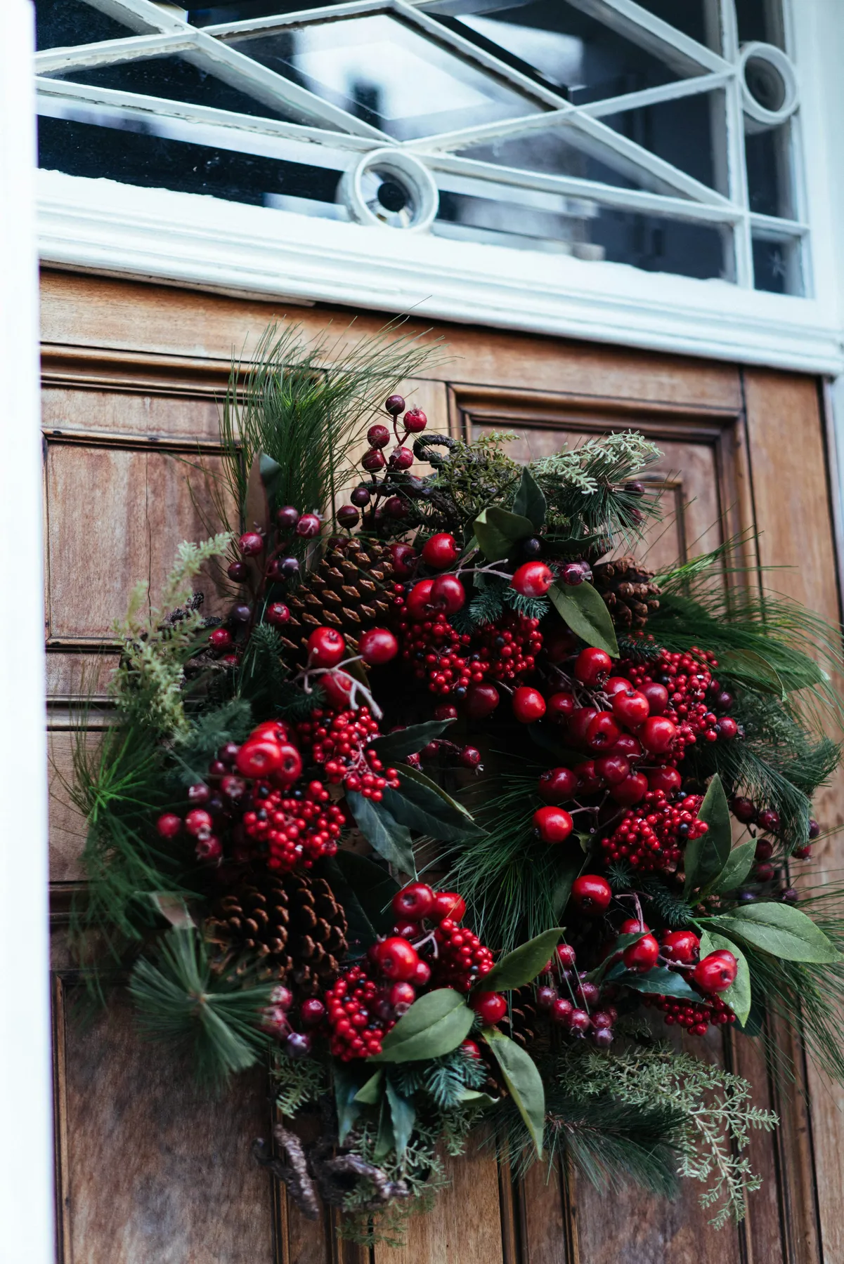 A festive christmas wreath adorns a wooden door - Free Photo on Unsplash
