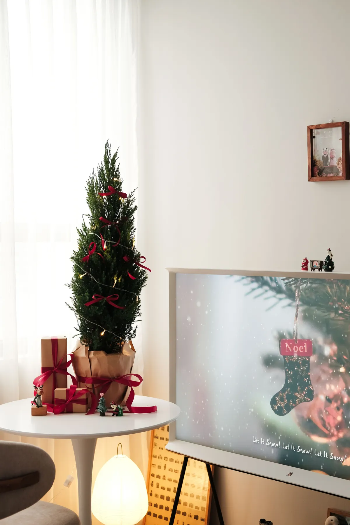 A festive indoor scene featuring a Christmas tree, gifts, and holiday decorations.