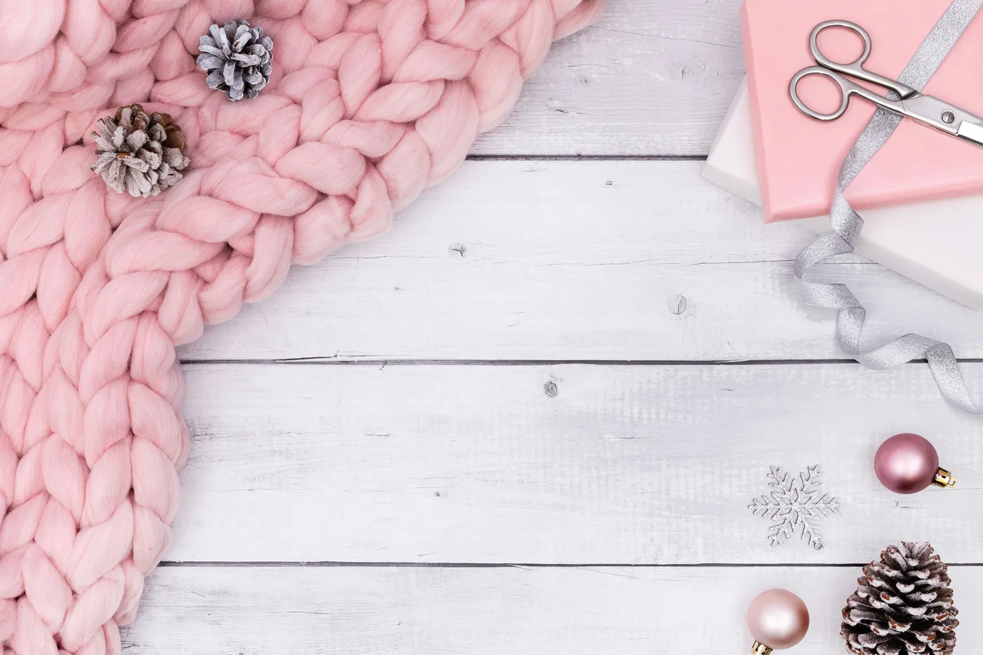 A flatlay photo. Taken on a white wooden table with pink and white Christmas props.