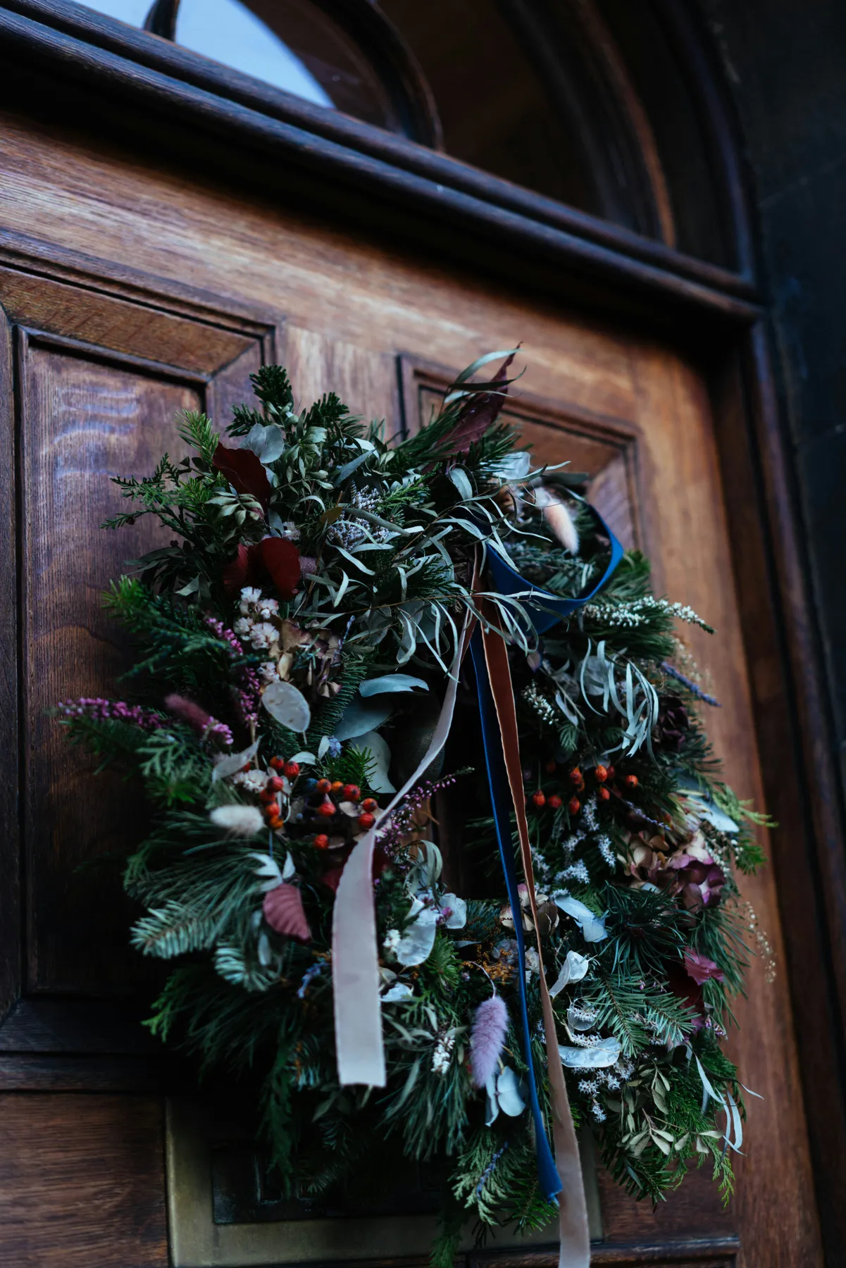 A rustic wreath hangs on a wooden door