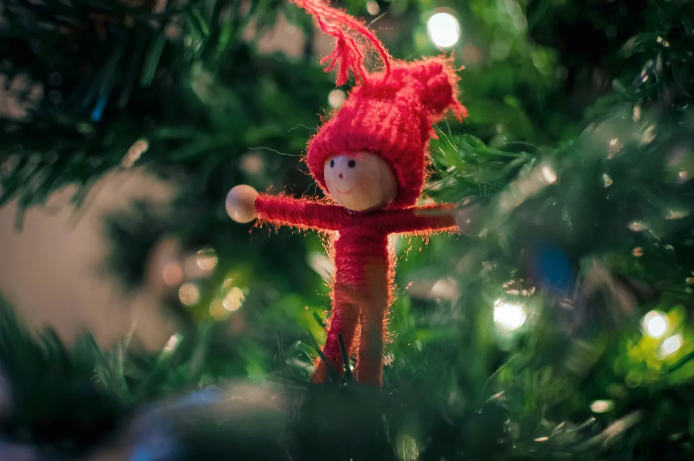 A small doll ornament on a christmas tree