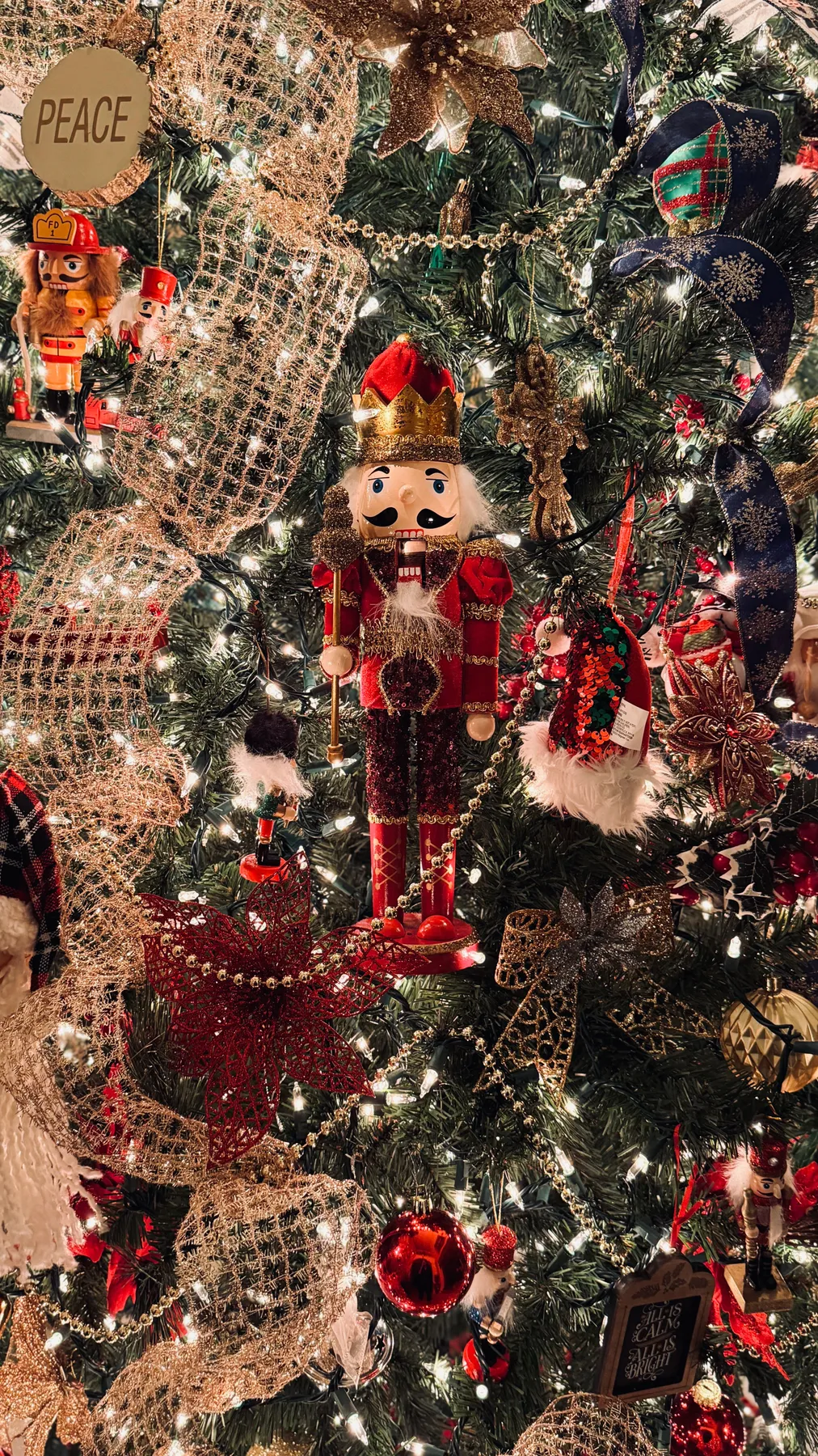 Beautifully decorated Christmas tree featuring a traditional nutcracker and festive ornaments.