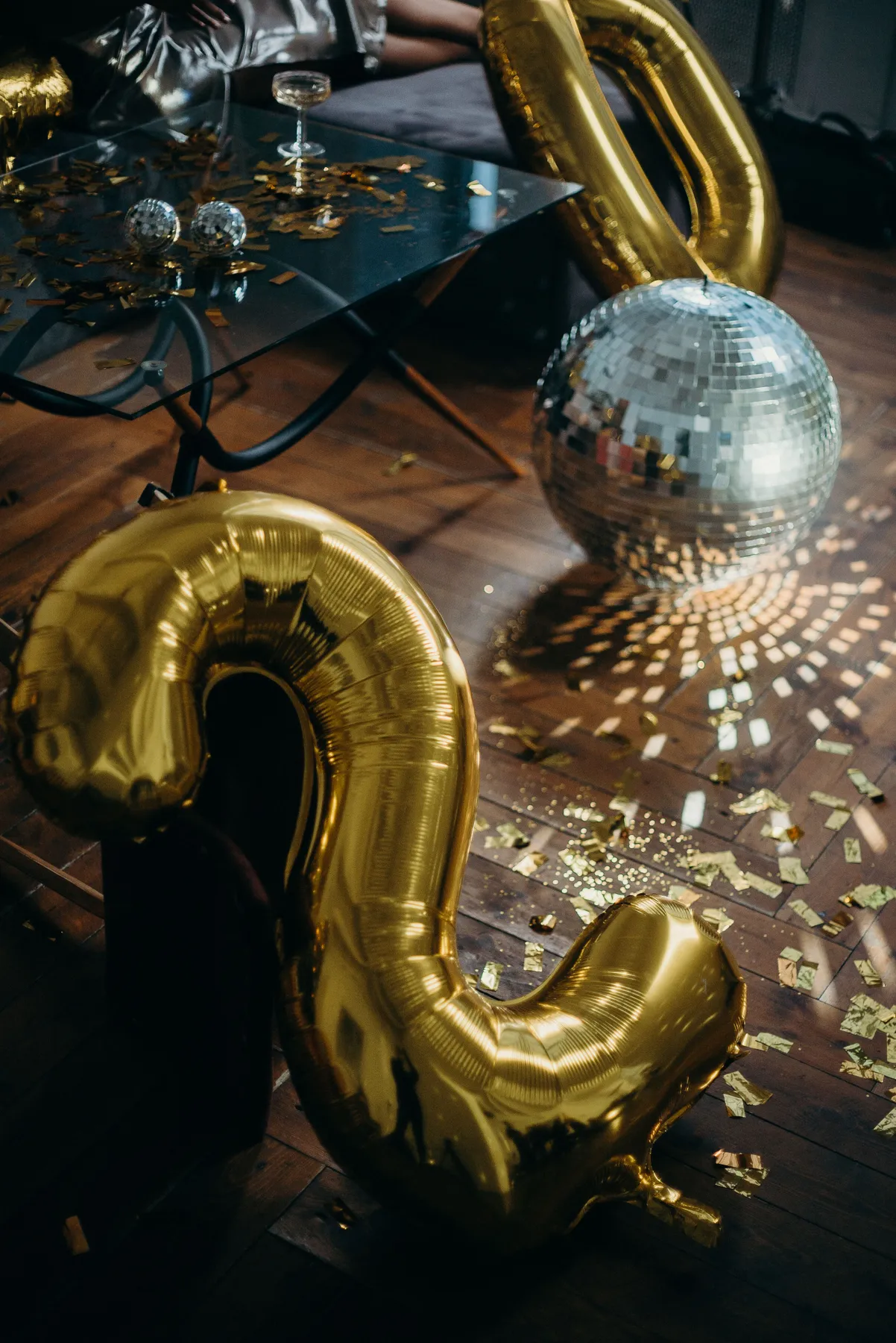 Capture the essence of New Year's celebration with a vibrant party setup featuring golden balloons and a shimmering disco ball.