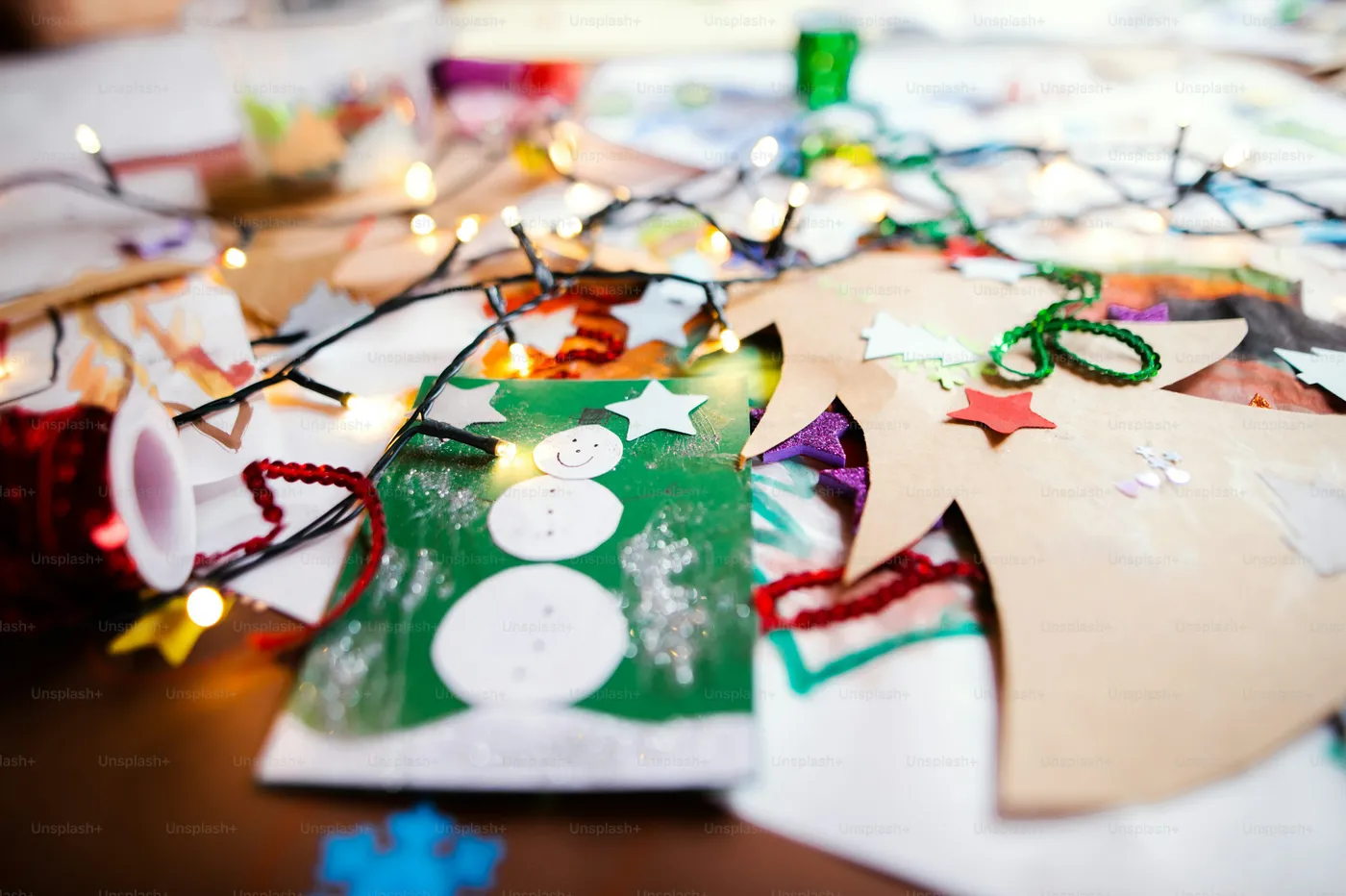 Children's paintings and Christmas paper art and craft indoors on table - Photo on Unsplash+