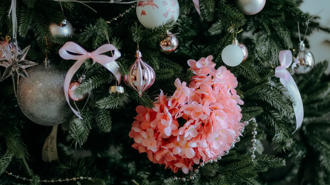 Christmas tree adorned with pink hydrangeas and sparkling ornaments, creating a festive and elegant look.