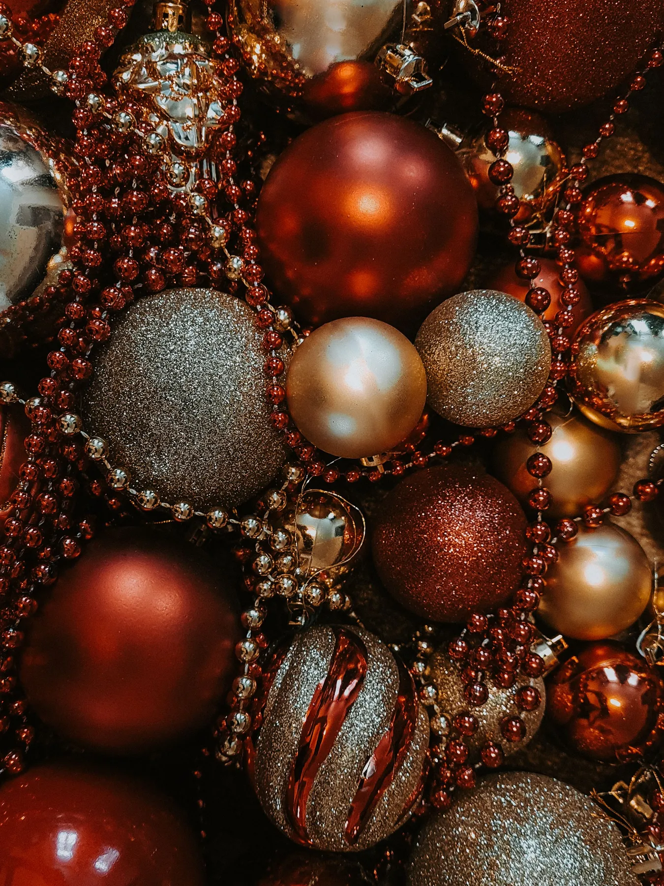 Close-up of red and gold Christmas baubles adorned with sparkling beads, creating a festive holiday atmosphere.