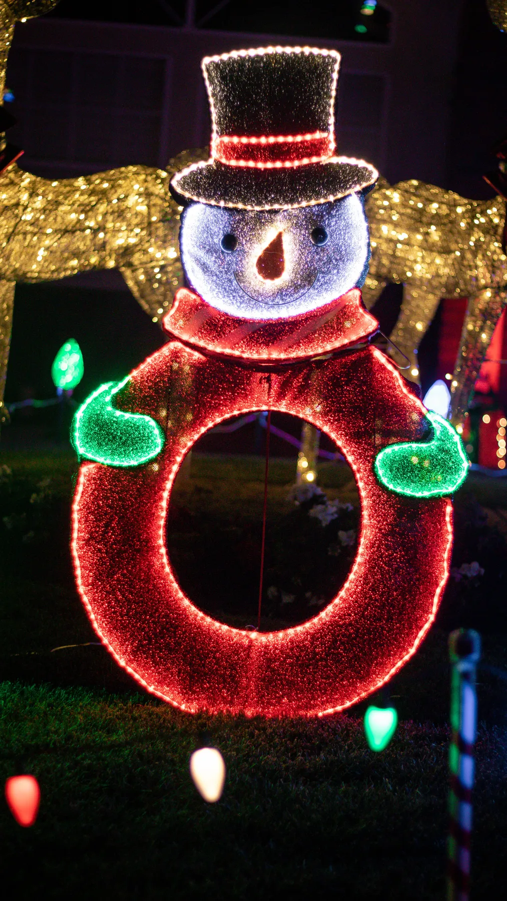 Colorful illuminated snowman decoration at night, perfect for holiday displays.