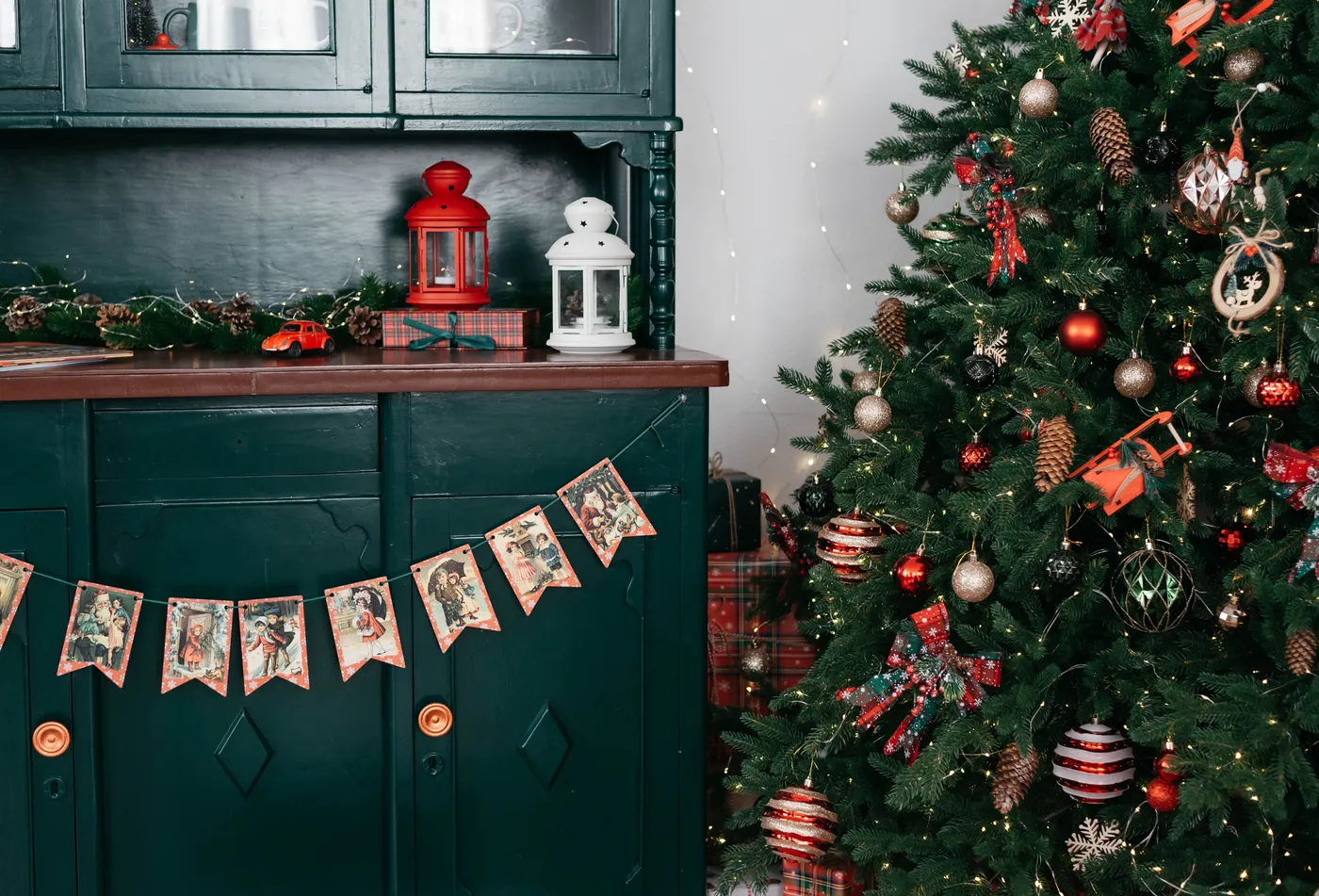 Cozy Christmas scene with decorated tree, lanterns, and vintage cards.