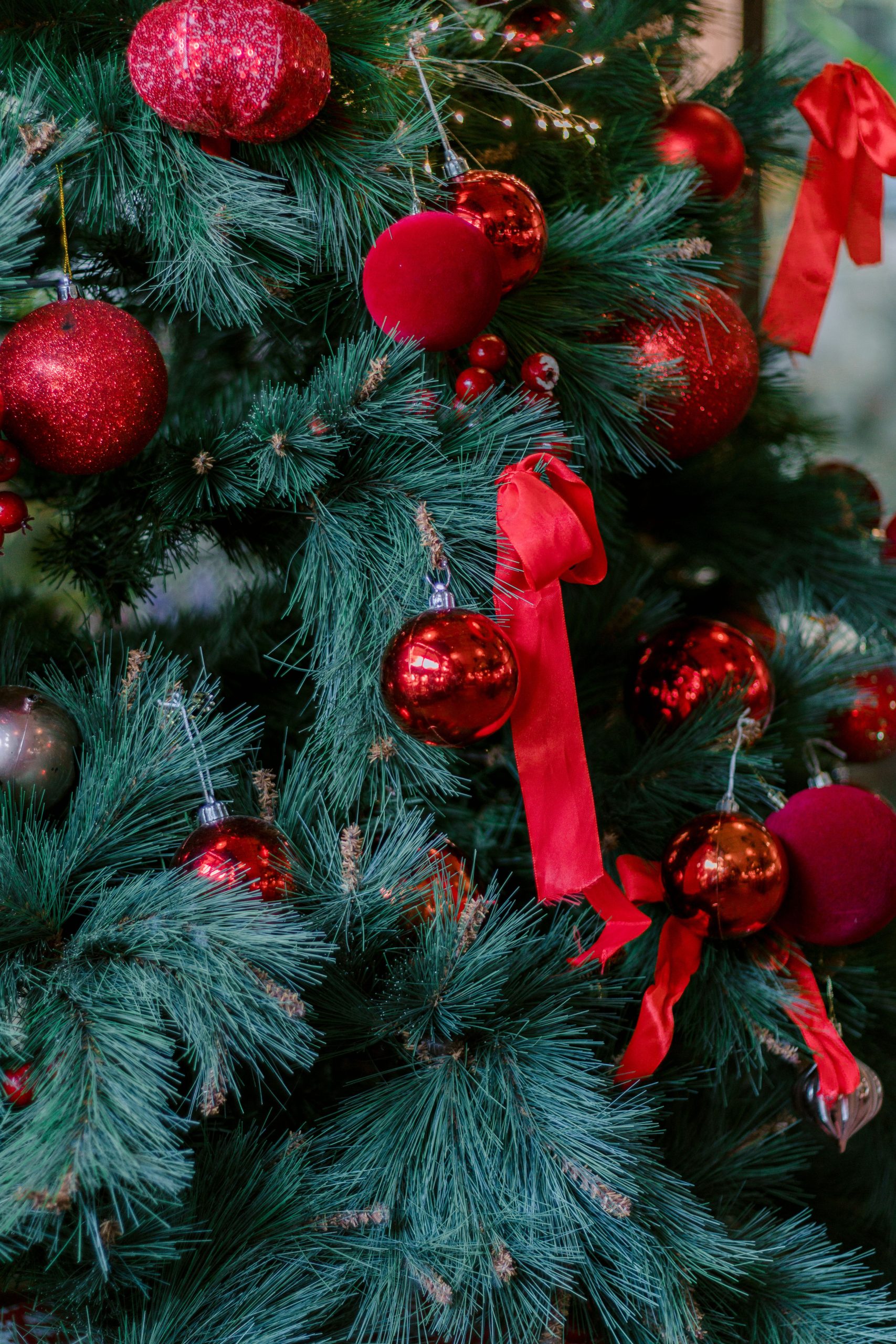 Decorative Christmas tree adorned with red baubles and ribbons, perfect for holiday ambiance.