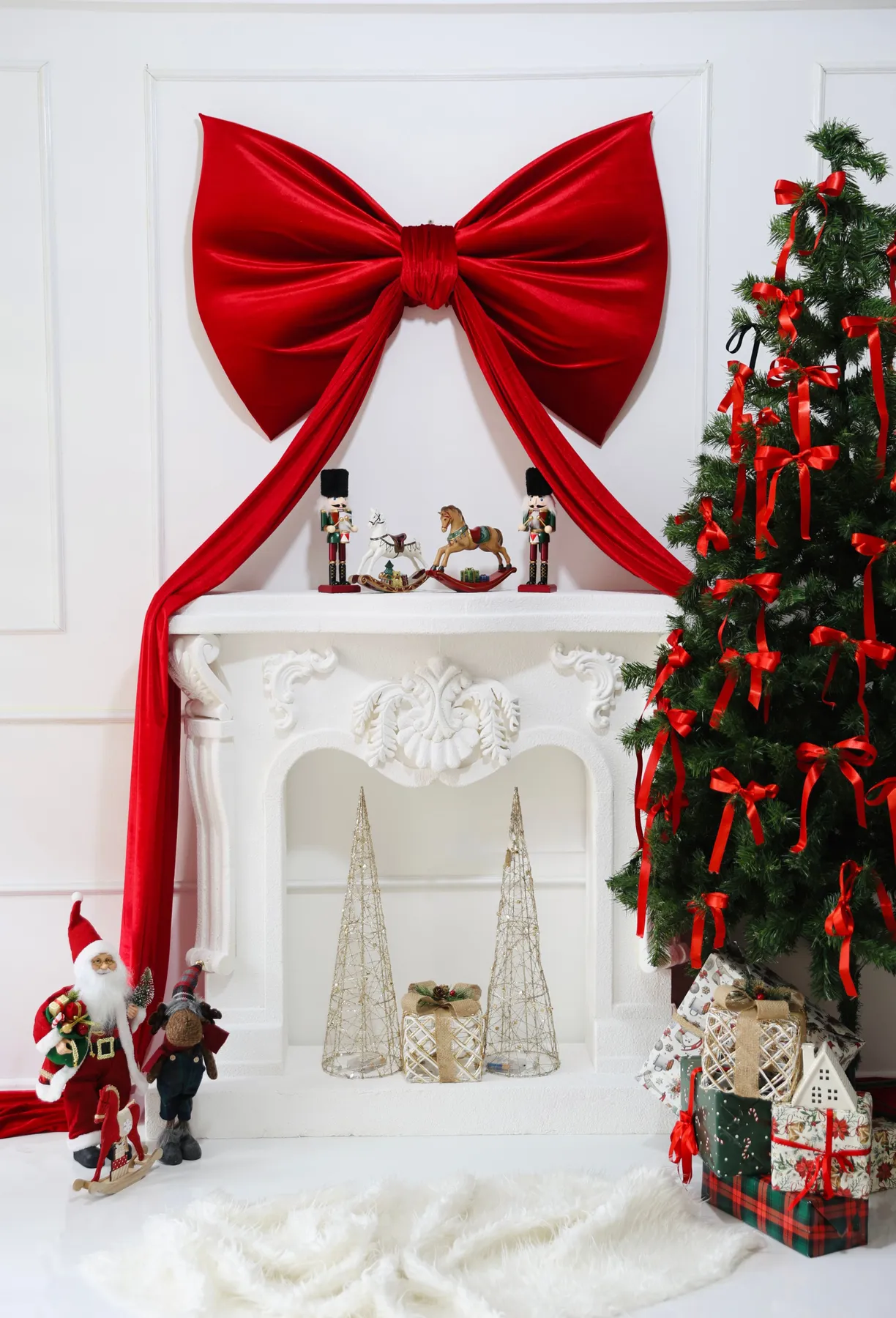Elegant holiday room setup with Christmas tree, presents, and red bow on fireplace.