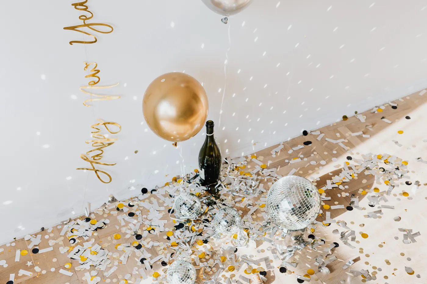 Elegant New Year celebration scene with balloons, champagne, and disco balls.