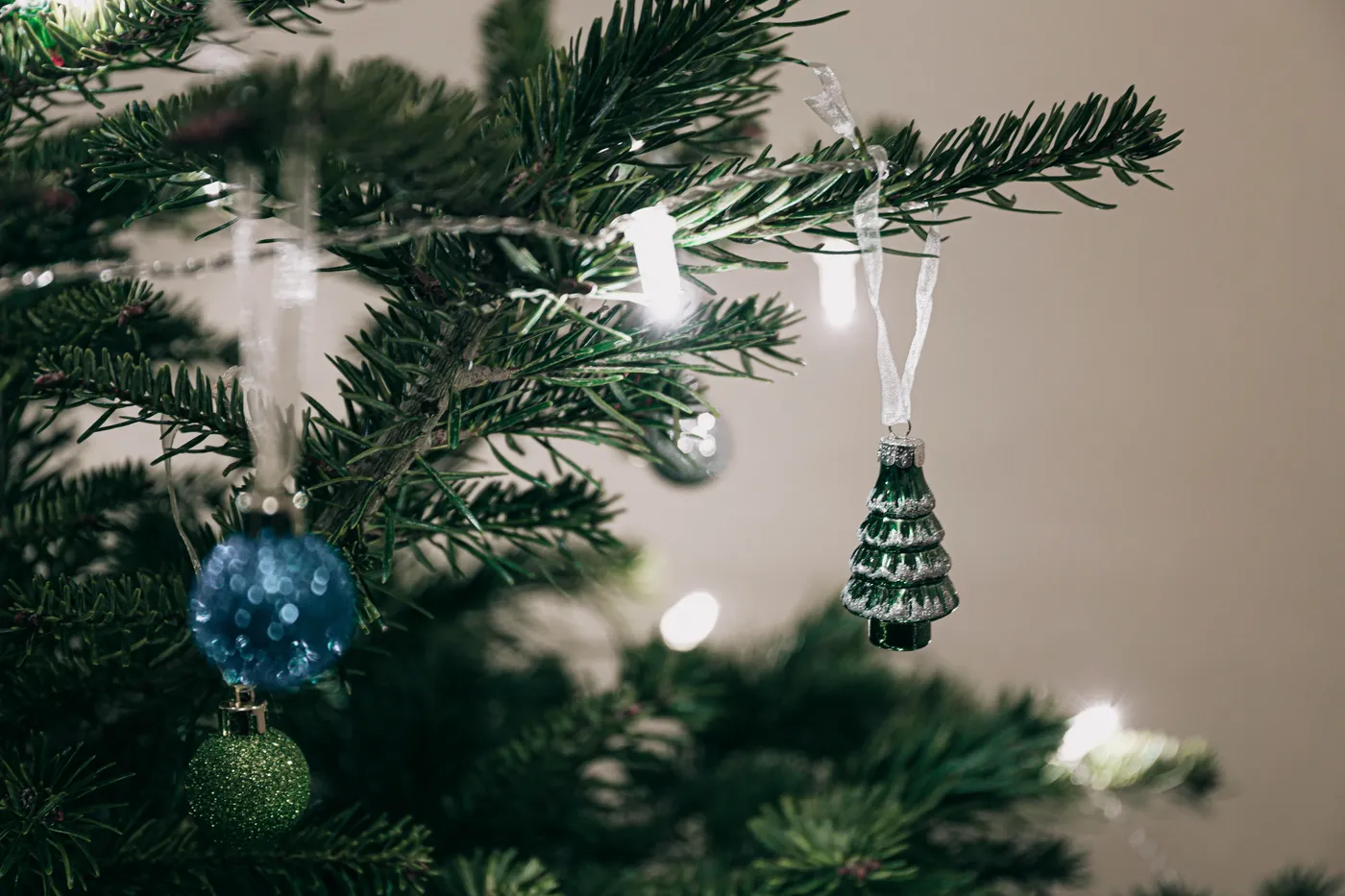 Festive Christmas tree decorated with ornaments and lights captured indoors.