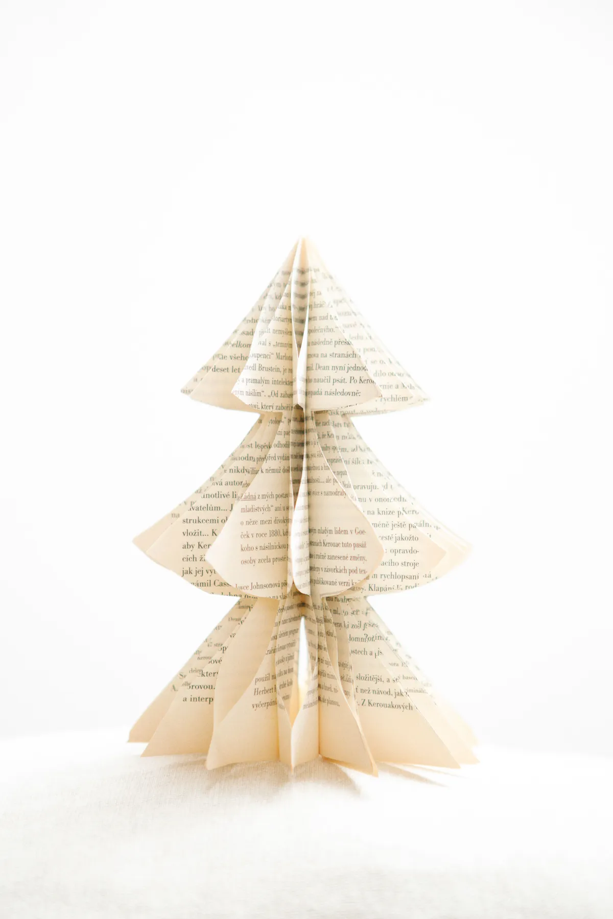 Minimalist handmade paper Christmas tree crafted with book pages, perfect for eco-friendly decor.