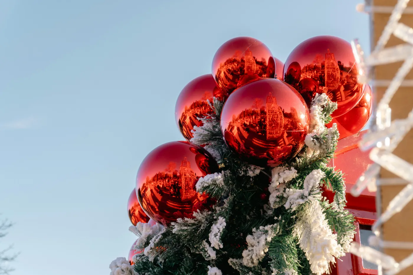 Red christmas ornaments on a snowy tree