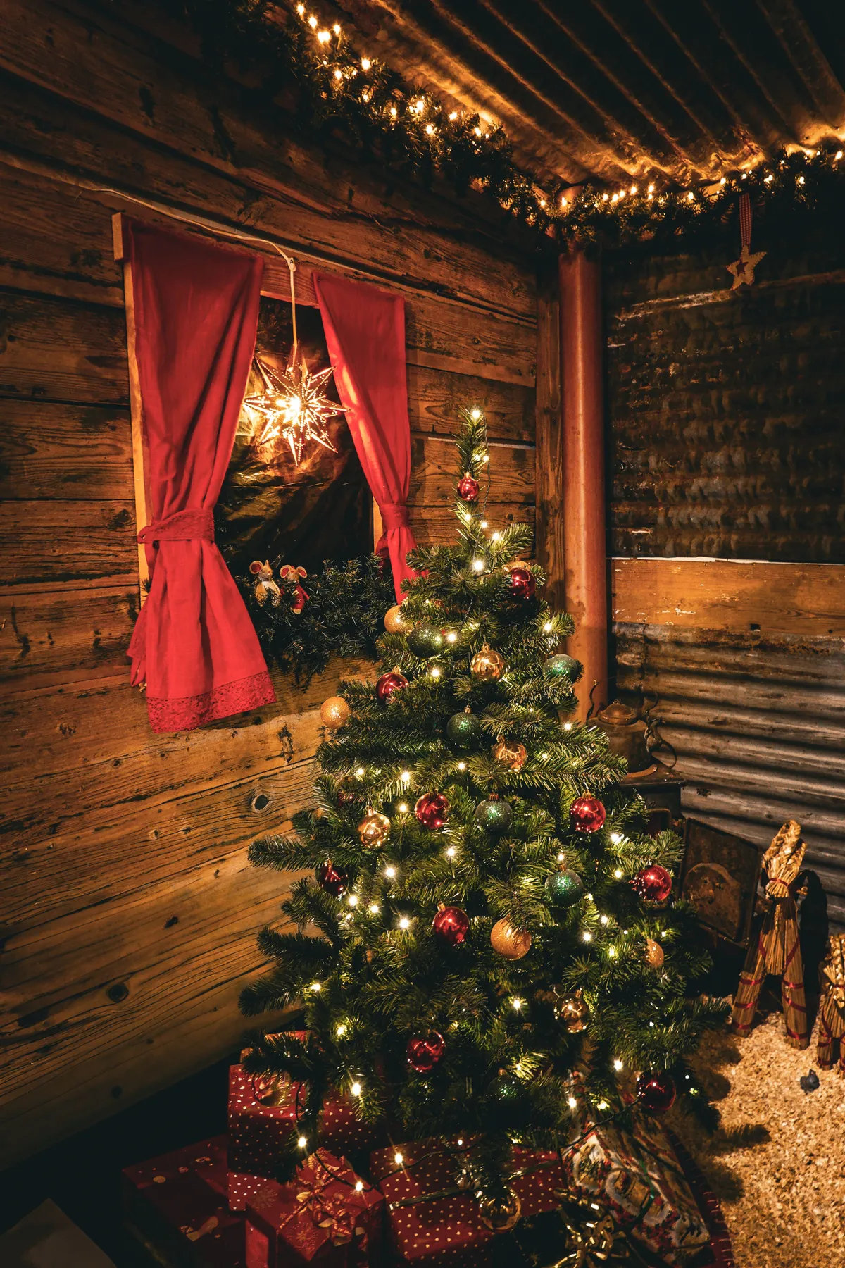 Warm and festive Christmas tree setting in a rustic wooden cabin interior.