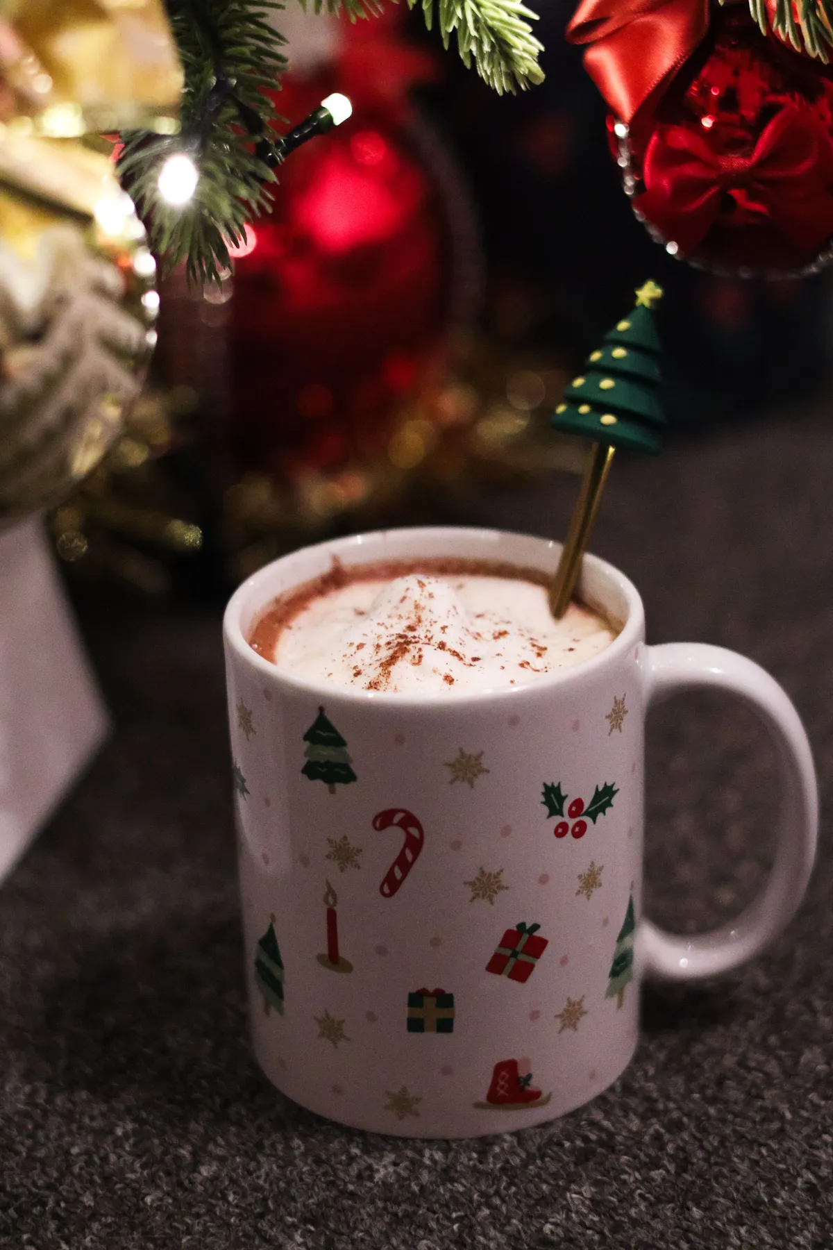 Warm holiday drink in a festive Christmas mug with decorations, perfect for cozy winter moments.