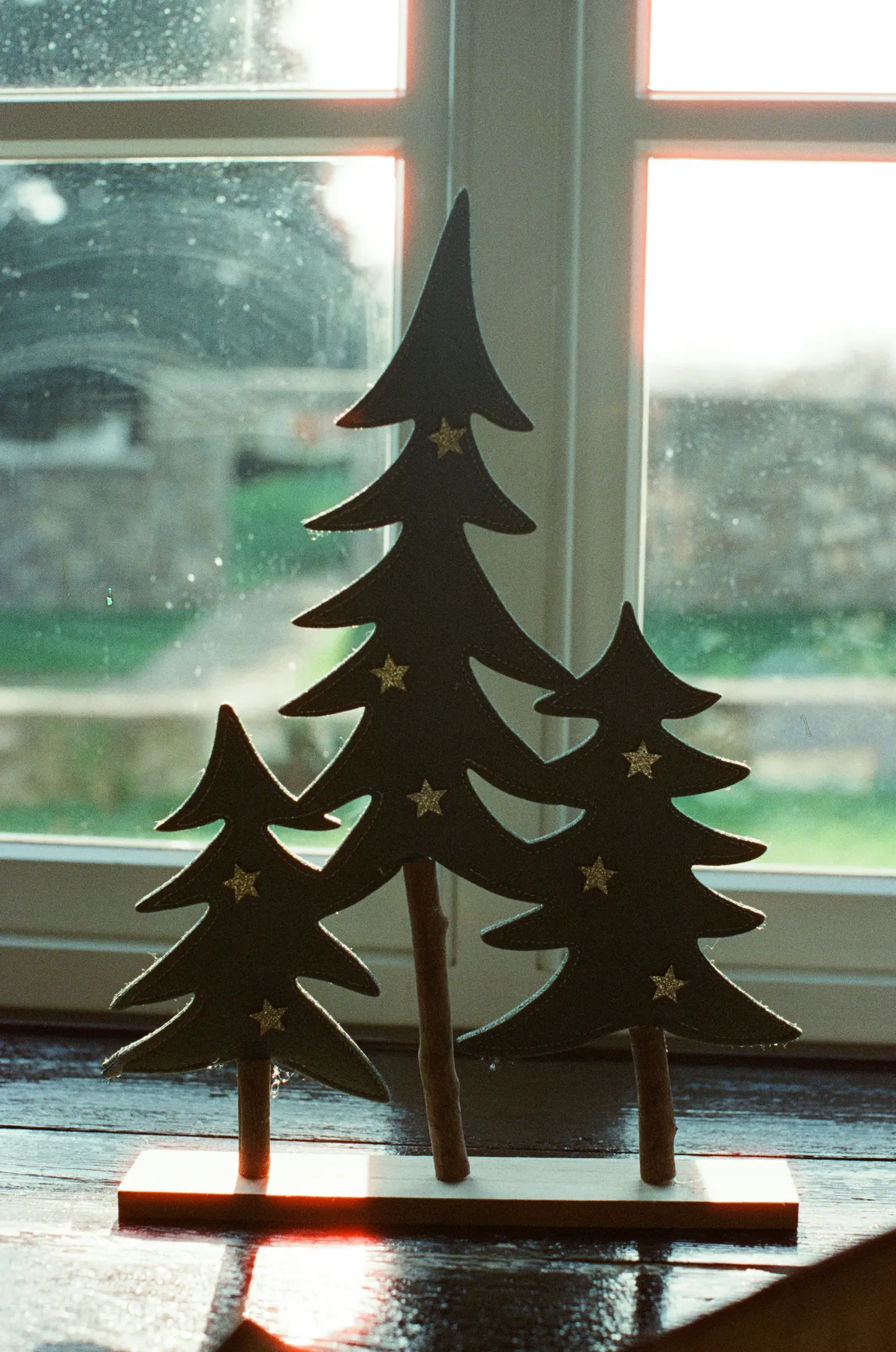 Wooden christmas trees with stars on windowsill